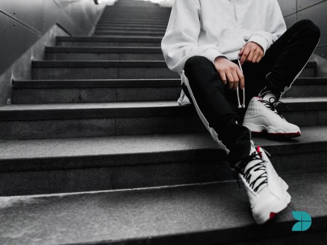 Streetwear fashion - Man sat in stairs wearing street wear clothing.