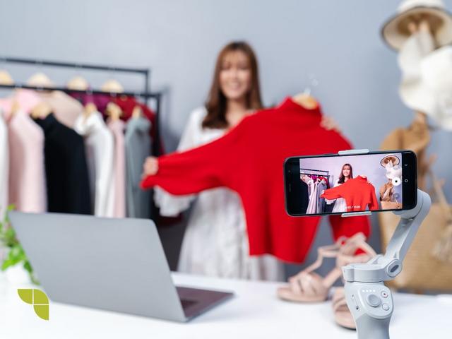 Young woman selling clothes online by smartphone live streaming business online e-commerce home