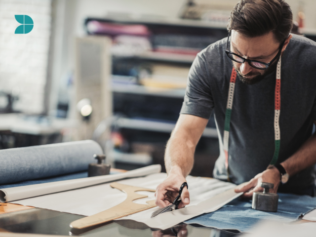 fashion designer cutting and creating pattern for fashion garment.