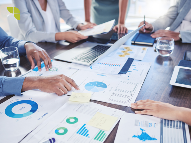 A group of marketers analysing reports and discussing findings.